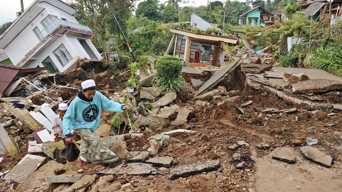 Local youths navigate their way through the rubble at a village affected by Mondays earthquake, in Cianjur, West Java, Indonesia, Wednesday, Nov. 23, 2022. More rescuers and volunteers were deployed Wednesday in devastated areas on Indonesias main island of Java to search for the dead and missing from an earthquake that killed hundreds of people. (AP Photo/Rangga Firmansyah)