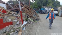 Seorang petugas berjalan diantara bangunan ambruk di Desa Benjot Kecamatan Cugenang (Foto: Ikbal Selamet/detikJabar)