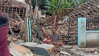 Korban bencana di Desa Cibulakan Kecamatan terduduk di depan rumah yang ambruk  (Foto: Ikbal Selamet/detikJabar)