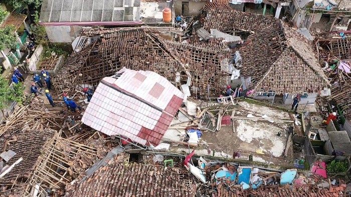 An aerial view shows rescue personnel working to rescue a child from the rubble of a collapsed house at Cugenang in Cianjur, West Java on November 24, 2022, following a 5.6-magnitude earthquake on November 21. - Survivors of an Indonesian earthquake that killed at least 271 people, many of them children, appealed for food and water November 23 as heavy rain and aftershocks hampered rescue efforts among the rubble of devastated villages. (Photo by ADEK BERRY / AFP) (Photo by ADEK BERRY/AFP via Getty Images)