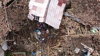 Tampilan udara menunjukkan petugas penyelamat bekerja untuk menyelamatkan seorang anak dari puing-puing rumah yang runtuh di Cugenang di Cianjur, Jawa Barat, Kamis (24/11/2022). Adek Berry/AFP/Getty Images  