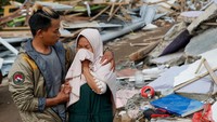 Seorang wanita menangis setelah menyaksikan rumahnya hancur akibat gempa Cianjur, 24 November 2022. REUTERS/Ajeng Dinar Ulfiana.