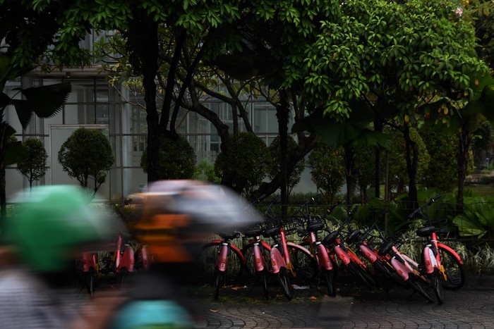 Layanan Sewa Sepeda di Trotoar Jakarta Nggak Laku, Kini Terbengkalai Pekerja melintas di dekat sepeda