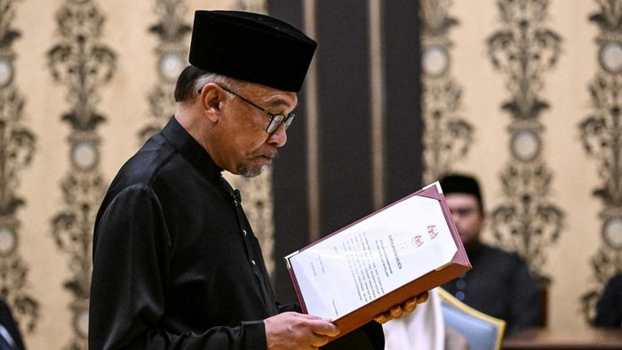 Malaysias newly appointed Prime Minister Anwar Ibrahim takes the oath during the swearing-in ceremony at the National Palace in Kuala Lumpur on November 24, 2022. (Photo by MOHD RASFAN / POOL / AFP)