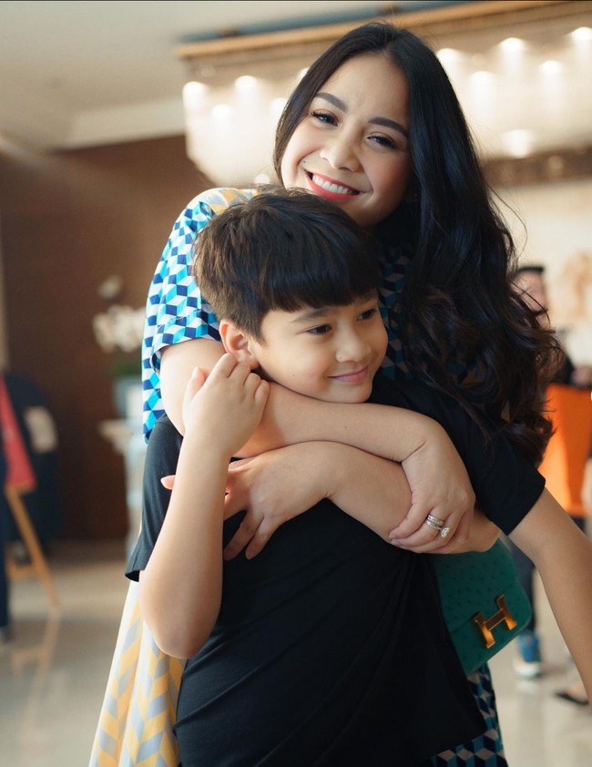 Berpose bersama anak pertamanya, Rafathar, begini gaya Nagita Slavina. Seperti biasa, penampilannya itu selalu terlihat santai dan riasan wajahnya pun natural. Mama gigi kalo lagi di luar negeri vibes nya gilak ya cantik banget bening, komentar netizen. Foto: Instagram/@raffinagita1717