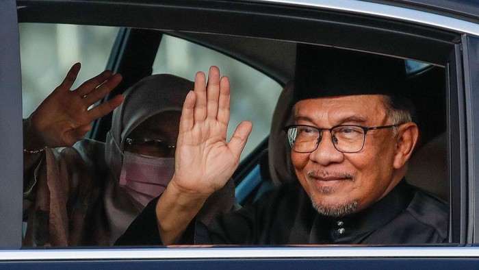 Malaysias newly appointed Prime Minister Anwar Ibrahim and his wife Wan Azizah Wan Ismail (L) wave as they arrive to take part in the swearing-in ceremony at the National Palace in Kuala Lumpur on November 24, 2022. (Photo by FAZRY ISMAIL / POOL / AFP) (Photo by FAZRY ISMAIL/POOL/AFP via Getty Images)