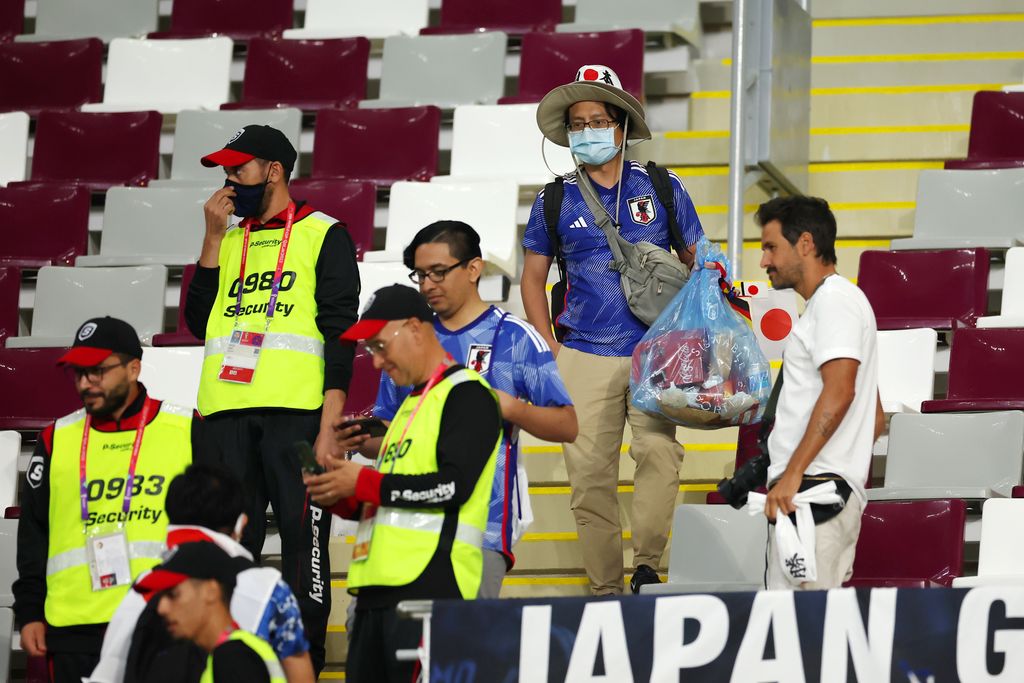 DOHA, QATAR - NOVEMBER 23: Japanese fans clear rubbish from the stands during the FIFA World Cup Qatar 2022 Group E match between Germany and Japan at Khalifa International Stadium on November 23, 2022 in Doha, Qatar. (Photo by Alex Grimm/Getty Images)