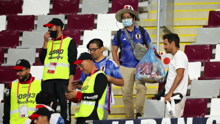 Salut! Suporter Jepang Punguti Sampah di Stadion Piala Dunia DOHA, QATAR - NOVEMBER 23: Japanese fans clear rubbish from the stands during the FIFA World Cup Qatar 2022 Group E match between Germany and Japan at Khalifa International Stadium on November 23, 2022 in Doha, Qatar. (Photo by Alex Grimm/Getty Images)