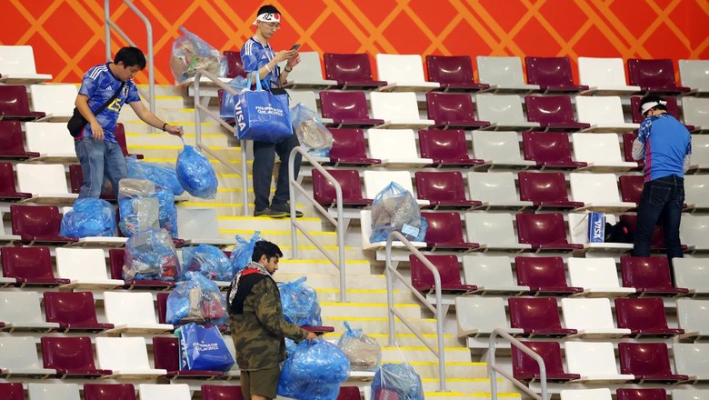 Salut! Suporter Jepang Punguti Sampah di Stadion Piala Dunia DOHA, QATAR - NOVEMBER 23: Japanese fans clear rubbish from the stands during the FIFA World Cup Qatar 2022 Group E match between Germany and Japan at Khalifa International Stadium on November 23, 2022 in Doha, Qatar. (Photo by Alex Grimm/Getty Images)