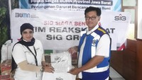 Lovy Nurmita Sari, Department of CSR SIG, menyerahkan bantuan paket sembako dan kebutuhan pokok lainnya kepada perwakilan Satgas BUMN Jawa Barat, Tatang Kusdiana di Posko Satgas BUMN Jawa Barat, Kabupaten Cianjur.