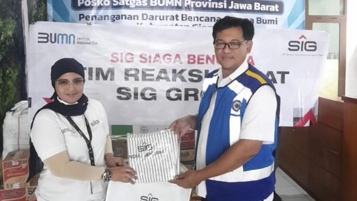 Lovy Nurmita Sari, Department of CSR SIG, menyerahkan bantuan paket sembako dan kebutuhan pokok lainnya kepada perwakilan Satgas BUMN Jawa Barat, Tatang Kusdiana di Posko Satgas BUMN Jawa Barat, Kabupaten Cianjur.