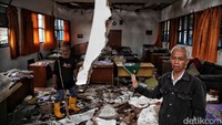 Puing-puing dinding sekolah berserakan di lantai. Getaran gempa yang kuat membuat dinding tersebut ambruk.