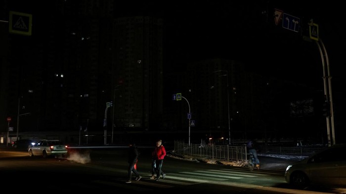 People cross a street without electricity after critical civil infrastructure was hit by Russian missile attacks, amid Russia's invasion of Ukraine, in Kyiv, Ukraine November 23, 2022. REUTERS/Valentyn Ogirenko