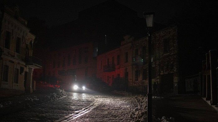 A vehicle drives past during a blackout after a Russian rocket attack in Kyiv, Ukraine, Wednesday, Nov. 23, 2022. Russia unleashed a new missile onslaught on Ukraine's battered energy grid Wednesday, robbing cities of power and some of water and public transport, too, compounding the hardship of winter for millions. The aerial mauling of power supplies also took nuclear plants and internet links offline and spilled blackouts into neighbor Moldova. (AP Photo/Andrew Kravchenko)