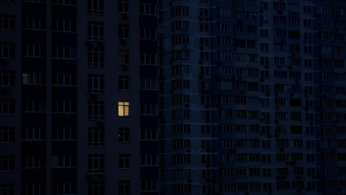 Light is seen inside an apartment in a residential building during a power cut amid Russias attack on Ukraine, in Kyiv, Ukraine November 20, 2022. REUTERS/Valentyn Ogirenko