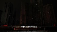 Sebuah trem terlihat melewati gedung apartemen yang gelap gulita di Kiev, Ukraina. Rusia kembali menembakkan rentetan rudal di berbagai wilayah Ukraina pada Rabu (23/11), yang menewaskan sedikitnya 10 orang. Reuters/Valentyn Ogirenko