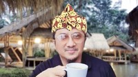 Yusuf Mansur menikmati secangkir minuman hangat saat mampir di rumah makan Sunda. Suasananya asyik karena berupa gubuk.