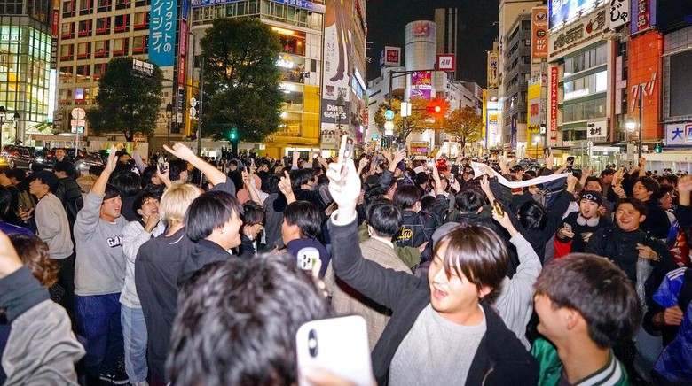Warga Tokyo Pestapora Usai Timnas Jepang Libas Jerman 2-1 People celebrate at Shibuya crossing in Tokyo, as Japans national soccer team won against Germany in the World Cup in Qatar, early Thursday, Nov. 24, 2022.(Kyodo News via AP)