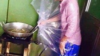 Untuk melindungi cipratan minyak panas, pria yang satu ini pilih membungkus dirinya dengan plastik besar.  Foto: Pool/Site
