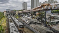 Kereta melaju di stasiun Kebayoran Lama, Jakarta, Kamis (24/11/2022). Terlihat dari jauh, para pekerja sedang menyelesaikan pembangunan jembatan penyeberangan orang (JPO) atau Skywalk. (ANTARA FOTO/Galih Pradipta)