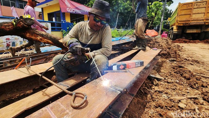 Cegah Banjir, Saluran Air di Kebon Jeruk Diperbesar Para pekerja menyelesaikan proses revitalisasi saluan air di Jalan Arjuna Selatan, Kebon Jeruk, Jakarta Barat. Saluran air dibuat lebih besar menggunakan beton u-ditch yang disangga dengan beton baja di sisi kiri dan kanan. Saluran ini mengalirkan curah hujan di daerah tersebut ke Kali Sekretaris. Kawasan Kebon Jeruk yang berada di sisi jalan tol kerap terancam genangan hingga banjir saat hujan deras. Hingga Jumat (25/11/2022) pekerjaan tersebut masih dikebut.
