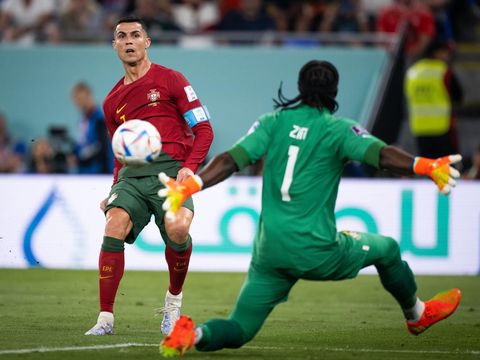 Cristiano Ronaldo (kiri) dari Portugal mencetak gol offside melawan Lawrence Ati Zigi (kanan) dari Ghana selama pertandingan Grup H Piala Dunia FIFA Qatar 2022 antara Portugal dan Ghana di Stadion 974 pada 24 November 2022 di Doha, Qatar. (Marvin Ibo Guengoer - GES Sportfoto/Getty Images)