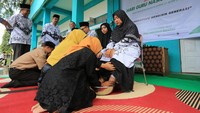 Sejumlah siswa-siswi membasuh kaki guru sebagai tanda penghormatan seusai upacara peringatan Hari Guru Nasional (HGN) 2022 di Madrasah Tsanawiyah Swasta (MTsS) Harapan Bangsa dan Madrasah Ibtidayah Negeri 11 Aceh Barat Desa Kuta Padang, Johan Pahlawan, Aceh Barat, Aceh, Jumat (25/11/2022). ANTARA FOTO/Syifa Yulinnas  