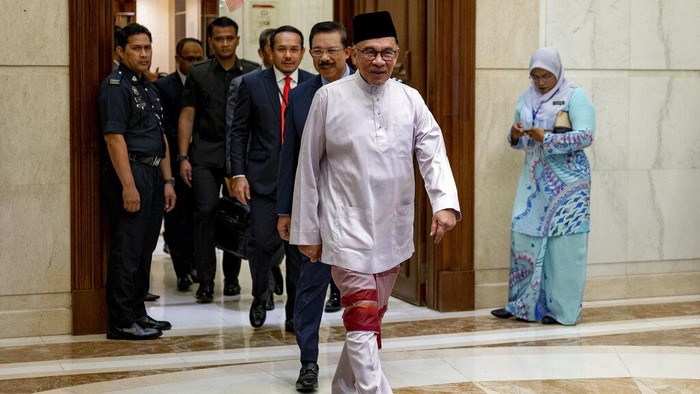 In this photo provided by Prime Minister Office, Malaysia's Prime Minister Anwar Ibrahim, front, arrives at the prime minister's office in Putrajaya, Malaysia on his first day Friday, Nov. 25, 2022. (Prime Minister office via AP)