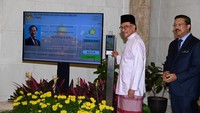 Mengenakan baju Melayu merah muda, Anwar Ibrahim tiba di kantor Perdana Menteri di Putrajaya sekitar pukul 09.55 waktu setempat dan diterima oleh kepala sekretaris pemerintah Zuki Ali, setelah dilantik oleh raja sehari sebelumnya. Departemen Penerangan Malaysia/Wazari Wazir/Reuters  