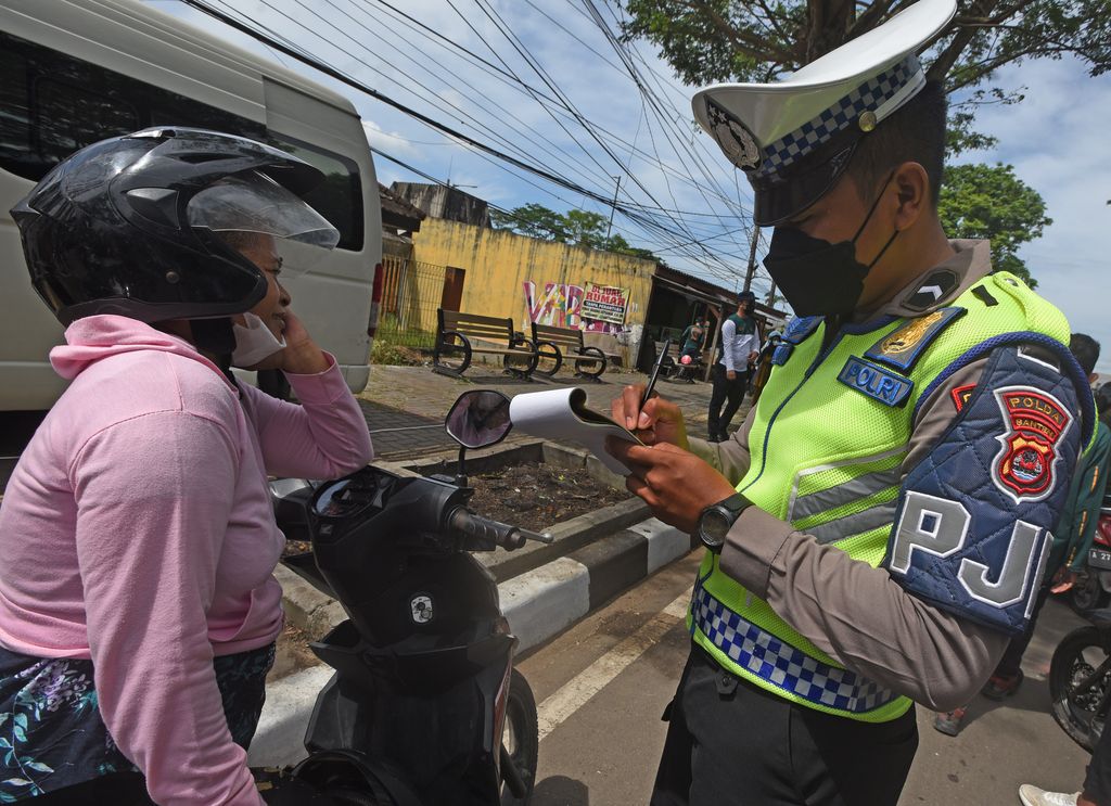 Anggota Polantas menilang warga yang kedapatan menunggak pajak kendaraan bermotor (PKB) saat melakukan razia di Serang, Banten, Jumat (25/11/2022). Razia digelar untuk meningkatkan kesadaran warga membayar PKB sekaligus mendongkrak pendapatan daerah. ANTARA FOTO/Asep Fathulrahman/aww.