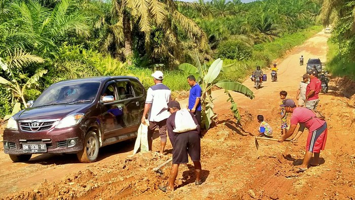 Warga tanam pohon pisang di jalan rusak Pelalawan. (Foto: Istimewa)