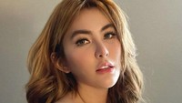 Angela Lee seringkali mengabadikan momennya saat bersantai. Salah satunya gaya saat ia menikmati segelas minuman hangat dengan dibalut pakaian putih dan riasan sederhana. Foto: Instagram/angelalee87