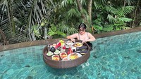 Disela-sela kesibukannya, Angela Lee tak pernah melewati waktu untuk berlibur. Waktu liburannya kali ini dibuka dengan sesi floating breakfast dengan pemandangan alam yang indah. Foto: Instagram/angelalee87