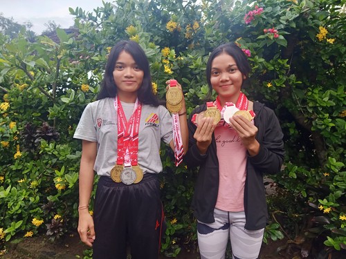 Kakak beradik Komang Ayu Suartini dan Ni Ketut Yunita Suarini menunjukan medali saat berlaga di cabor panjat tebing Porprov Bali 2022, Sabtu (26/11/2022).