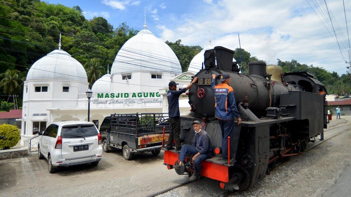 Masinis menjalankan lokomotif uap E1060 