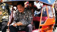 Tampak Menko Marves Luhut Binsar Pandjaitan menumpangi bentor agar mobilisasi yang lebih mudah di lokasi acara, mengingat padatnya area oleh masyarakat. 