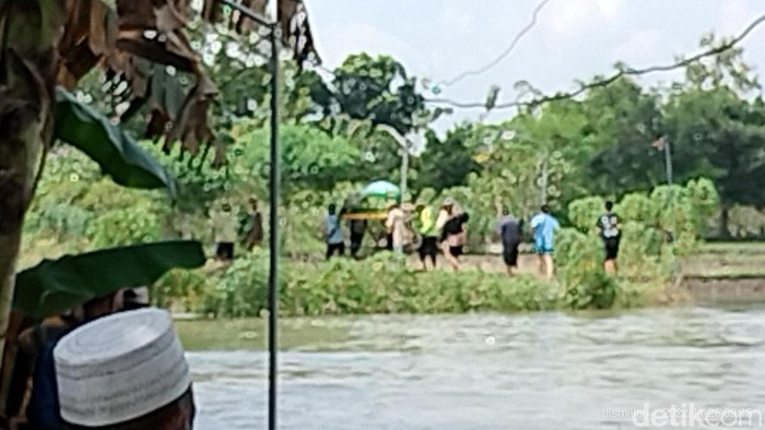 Pemakaman di tengah banjir luapan Sungai Pacal Bojonegoro