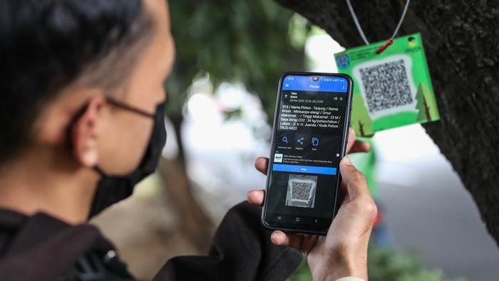 Pemkot Depot Habiskan Rp49 Juta Demi Pasang Barcode di 1.500 Pohon Warga berjalan disamping pohon yang dipasang