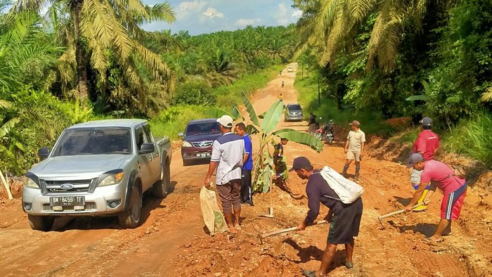 Warga saat tanam pohon di jalan rusak