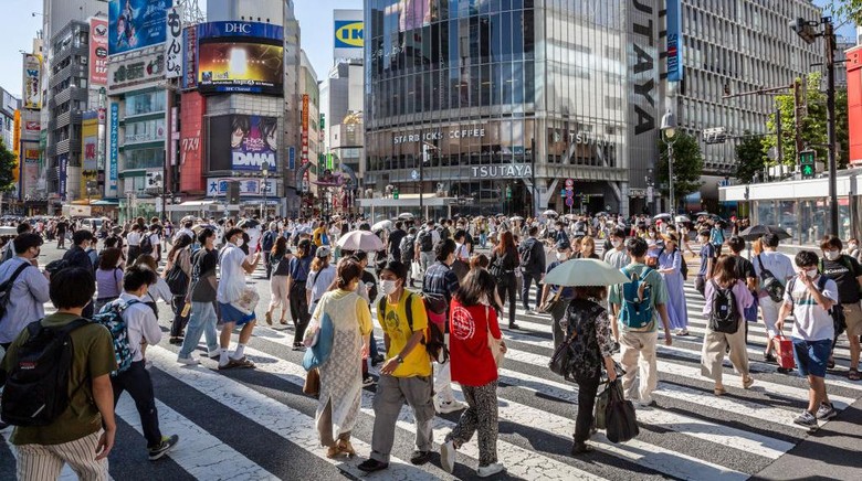TOKYO, JAPAN - JULY 29: People wearing face masks cross Shibuya crossing on July 29, 2022 in Tokyo, Japan. The World Health Organization (WHO) announced that Japans COVID-19 cases between July 18 to 24 reached 970,000, the highest in the world. (Photo by Yuichi Yamazaki/Getty Images)