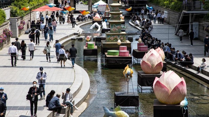 4 Negara Ini Dihantui Resesi Seks, Terancam Krisis Populasi Office workers take a rest during a sunny day near lanterns displayed for the upcoming celebration of Vesak day at the Cheonggyecheon stream on May 19, 2021 in Seoul, South Korea. (Photo by Chris Jung/NurPhoto via Getty Images)