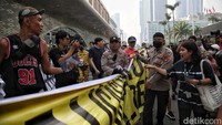 Sejumlah warga yang berada di kawasan CFD HI juga ikut menyoraki petugas yang menarik paksa spanduk tersebut. 