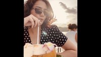 Ini adalah momen Citra Kresna saat liburan ke pantai di Bali. Sambil liburan ia mampir ke kafe pinggir pantai dan menikmati air kelapa. Foto: Instagram @citra_kresna