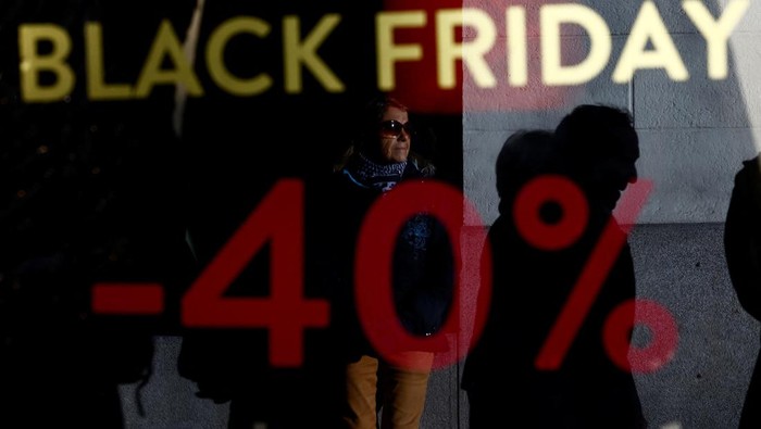 People walk past a Black Friday sale sign on a shop window in Nantes, France, November 25, 2022. REUTERS/Stephane Mahe