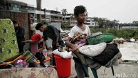 Sejumlah warga mengemas barang-barang usai angin puting beliung menerjang rumah semi permanen yang ditempatinya.  