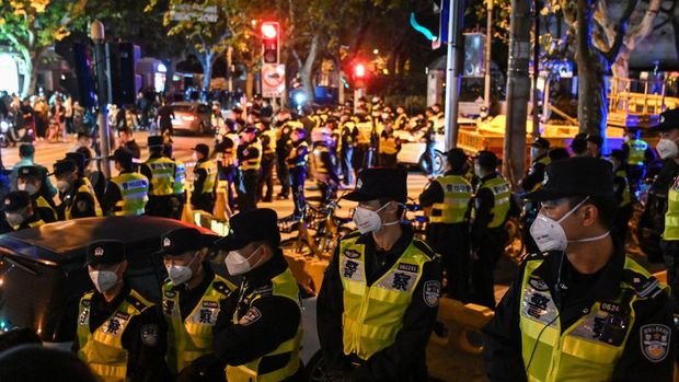 Police officers block Wulumuqi street, named for Urumqi in Mandarin, in Shanghai on November 27, 2022, in the area where protests against China's zero-Covid policy took place the night before following a deadly fire in Urumqi, the capital of the Xinjiang region. (HECTOR RETAMAL/AFP via Getty Images)