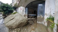 Batu dan lumpur terlihat di depan toko yang banjir setelah hujan deras memicu tanah longsor yang meruntuhkan bangunan di pulau Ischia, Italia. 