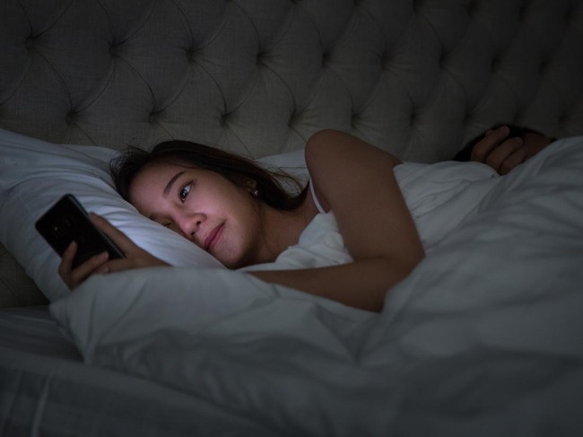 Young Couple On Bed With Smart Phone