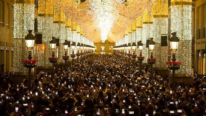 Antusias Warga Spanyol Saat Lampu-lampu Natal Menyala MALAGA, SPAIN - 2022/11/26: People are seen using their mobile phones to take pictures as they look at the lights during the switching on of the Christmas lighting at Marques de Larios street. Amid energy crisis and the increase of price electricity, Malaga city turns on its Christmas lights to mark the Christmas season, where thousands of people gather in downtown city to see a new Christmas decoration and lights show. (Photo by Jesus Merida/SOPA Images/LightRocket via Getty Images)