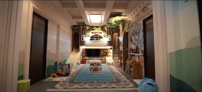 Playhouse tersebut tampak dilengkapi dengan perosotan, tangga yang bisa dijadikan rak penyimpanan, ruangan di bagian atas yang bisa dijadikan tempat Arsy bernyanyi, dan berbagai macam mainan. Pada bagian tengahnya juga disediakan meja dan kursi untuk Arsy dan Arsya bermain puzzle, melukis, mewarnai, dan semacamnya. Foto: YouTube/The Hermansyah A6